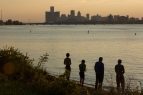 Young men stand on the shores of the Detroit River on Belle Isle in Detroit on Sept. 5, 2016.